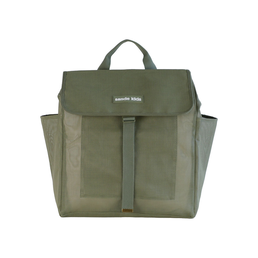A studio image of the Sande Kids™ Beach Hauler mesh backpack in Pandanus Green, shown from the front to highlight its details. The backpack features a flap with a plastic clip, adjustable strap, large side mesh pockets, and a handle at the top. Set against a white background.