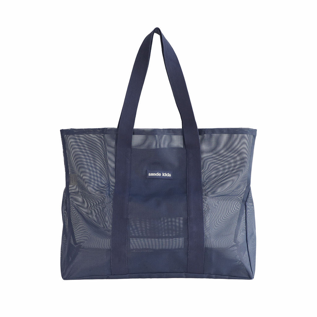 Oversized Sande Kids Beach Hauler mesh beach bag in Deep Sea Navy, displayed in a studio setting. Shown front-on to highlight the mesh detail, thick cotton straps, and silicone Sande Kids logo. Set against a white background.