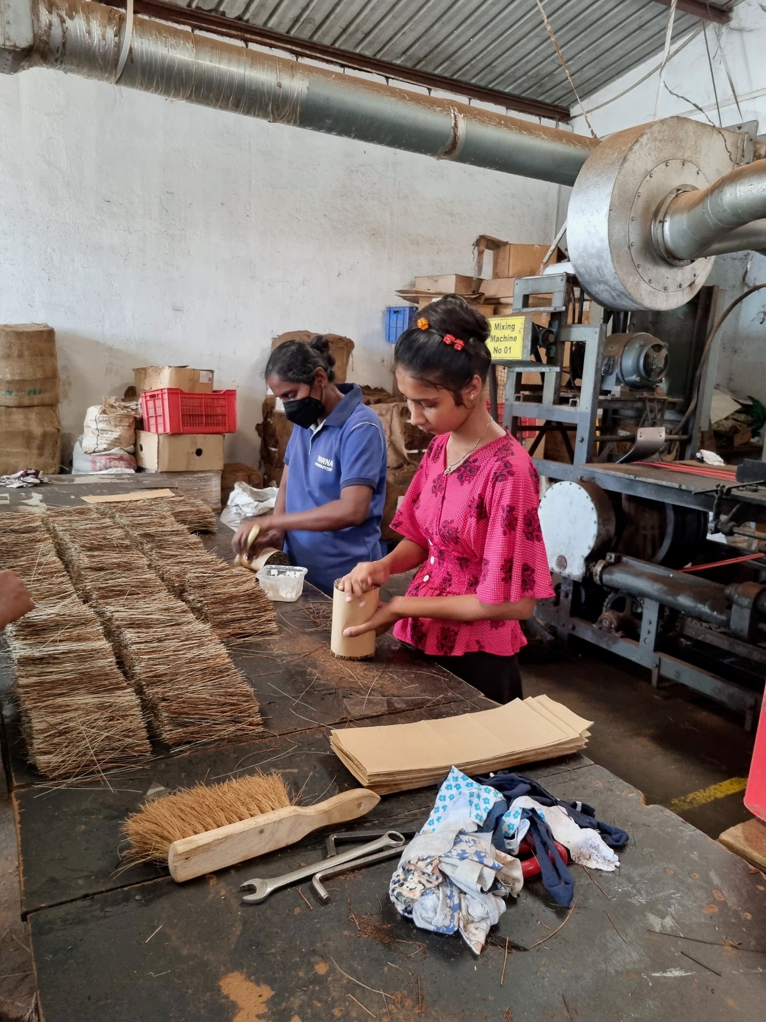 Two women in a brush factory in Sri Lanka preparing the jute and coconut fibre bristles for the Sand Kids sand brush.