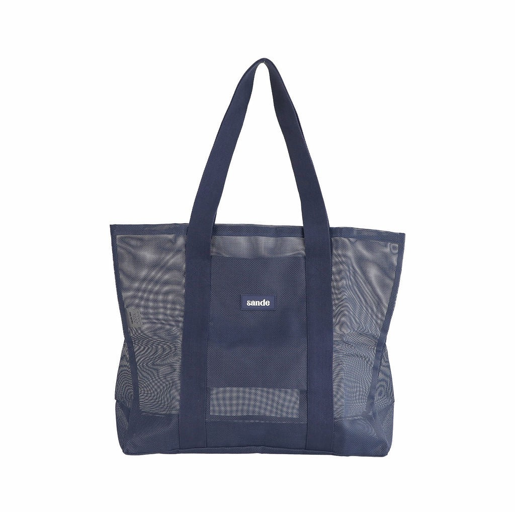 Sande Kids Beach Hauler - large mesh beach bag in Deep Sea Navy, displayed in a studio setting. Shown front-on to highlight the mesh detail, thick cotton straps, and durable construction. shows silicon label with Sande logo. Set against a white background.