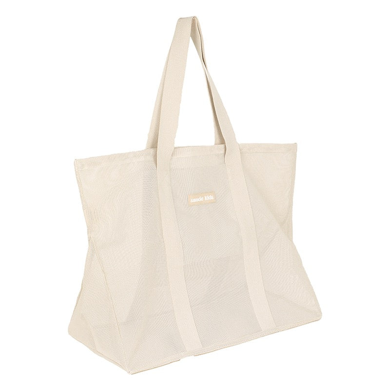 Side view of the Sande Kids original oversized mesh beach bag in neutral.