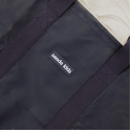 Close-up of the high-quality features of the Sande Kids Beach Hauler mesh beach bag in Deep Sea Navy. Highlights the durable PVC mesh fabric, thick cotton straps, and silicone Sande Kids logo.