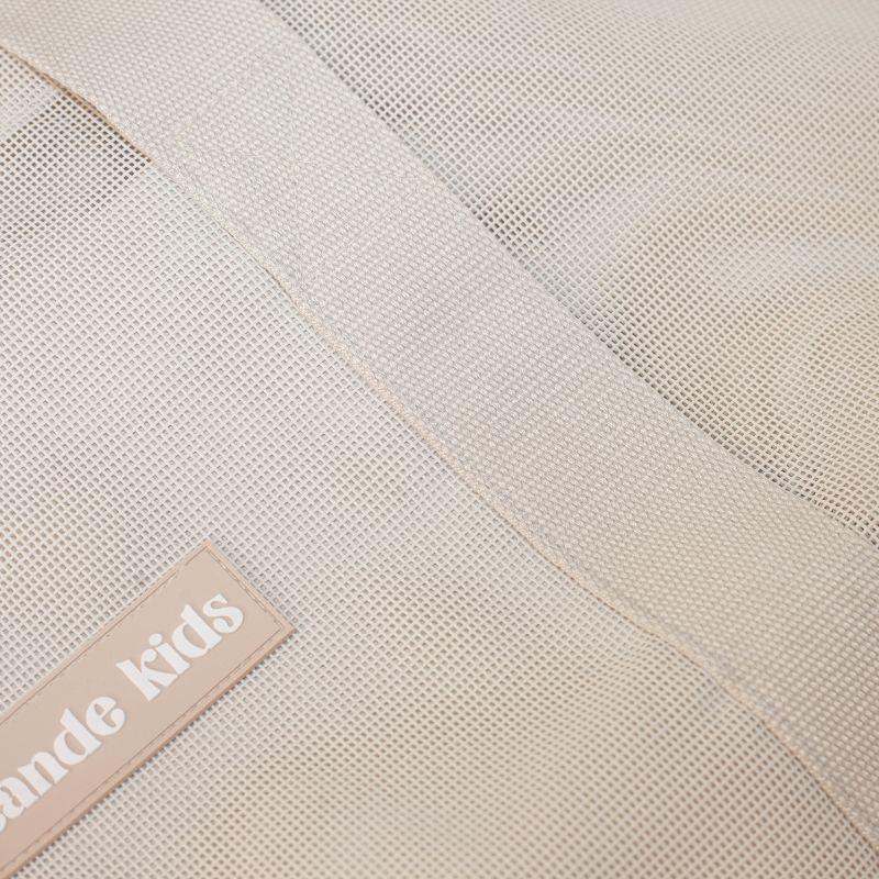 Sande Kids original mesh beach bag in Sand. A beautiful neutral. Images shows the mesh fabric, cotton straps and silicone label.
