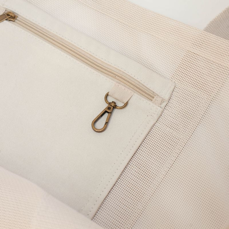 Close-up image of the Sande Kids Beach Hauler™ mesh beach bag showcasing the durable canvas pocket and brushed bronze key clip, designed for convenient organisation of beach essentials.