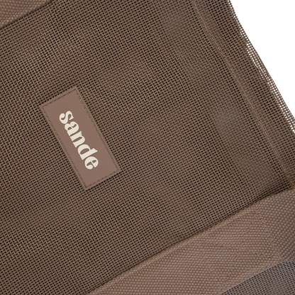 Close-up image of the Sande Kids™ Beach Hauler oversized mesh bag in Espresso Brown, highlighting the durable mesh fabric, thick cotton straps, and silicone Sande logo. Perfect for carrying beach essentials on family beach days, market trips, and outdoor adventures.