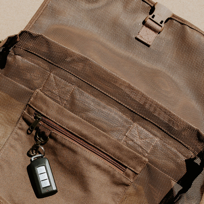 Close-up of the internal secure canvas pocket and key clip in the Sande Beach Hauler mesh backpack in Espresso chocolate brown, designed to keep valuables safe.