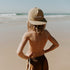 A little boy at the beach, with the ocean in the background, standing with his hands on his hips. He’s wearing the Sande Kids™ cap on backwards, showcasing the embroidered Sande Kids logo.
Cap is lightweight, fast-drying nylon. Perfect for outdoor adventures.