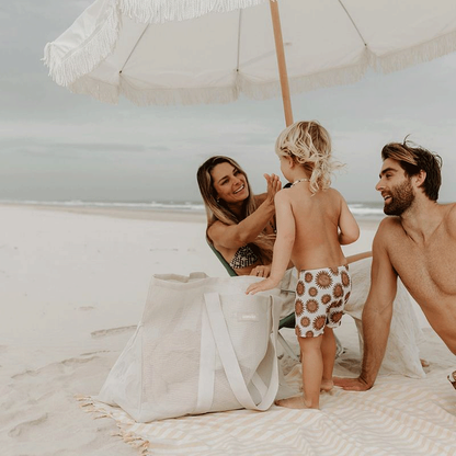 Family enjoying a day at the beach with their Sande Kids Beach Hauler oversized mesh beach bag in Sand, highlighting the bag&